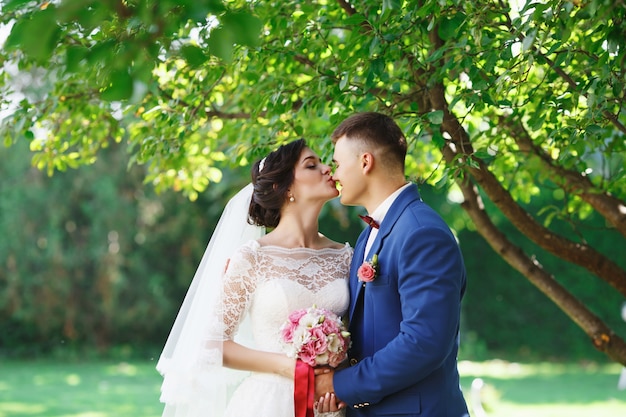 La novia y el novio posando en un parque