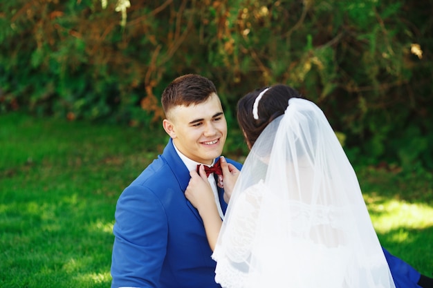 La novia y el novio posando en un parque