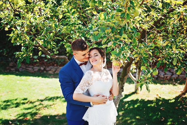 La novia y el novio posando en un parque