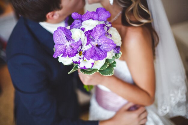 La novia y el novio con un ramo de flores de boda