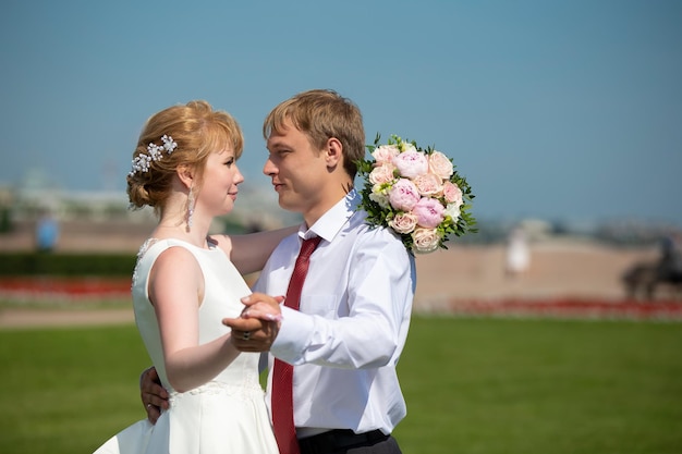 La novia y el novio Los recién casados se miran contra el cielo