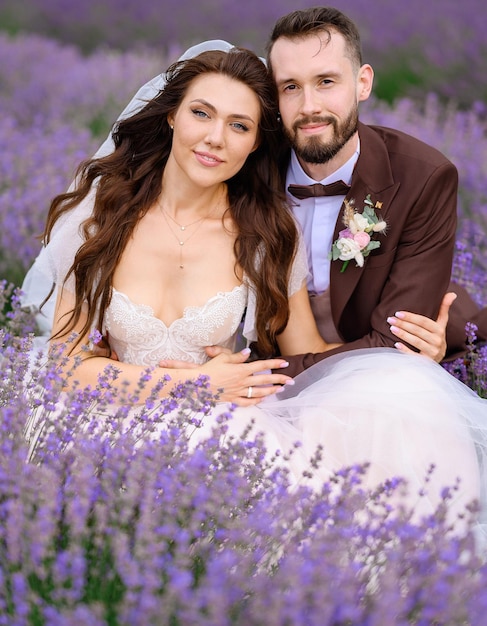 novia y novio, sentado, en, campo, con, púrpura, flores