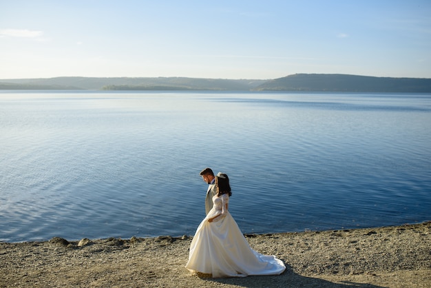 Novia y novio siendo romántico cerca de un lago