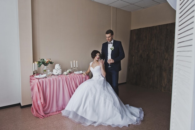 La novia y el novio se sientan en la mesa del banquete 6450