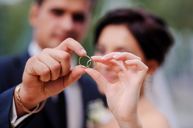 Novia y novio tomados de la mano en un anillo