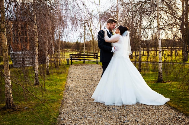 Una novia y un novio tomados de la mano el día de su boda en un jardín.