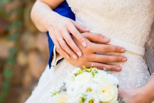 La novia y el novio tomados de la mano con un ramo