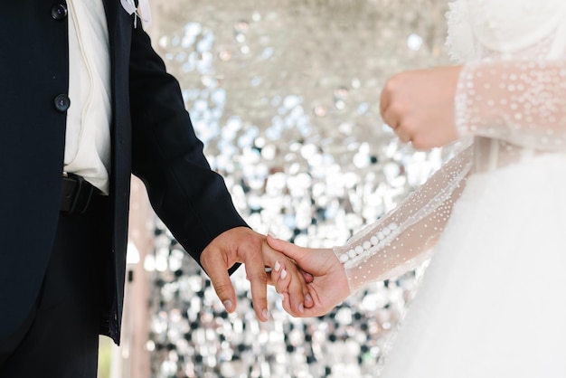 La novia y el novio se toman de la mano en la vista inferior de la ceremonia de boda