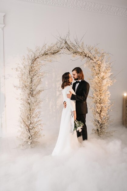 novia y novio vestidos de novia en un interior luminoso en el retrato familiar del día de la boda