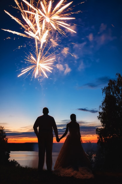 La novia y el novio viendo los fuegos artificiales, silueta