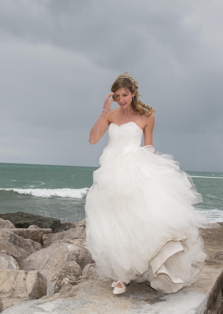 Novia parada cerca del océano esperando a su amante