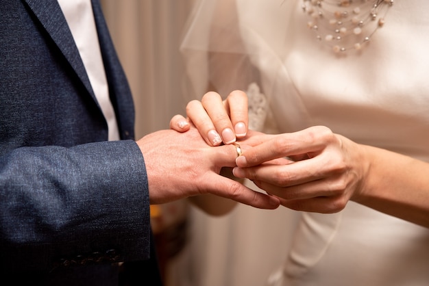 La novia le pone el anillo al novio. Boda