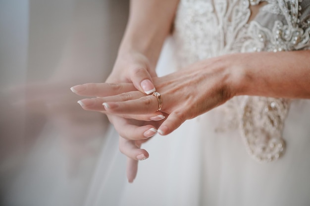 La novia pone un anillo de bodas en el dedo Primer plano de las manos de la mujer que muestra un elegante anillo de diamantes en el dedo amor y concepto de boda Compromiso Enfoque suave y selectivo