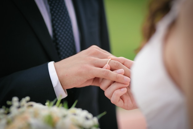 La novia pone el anillo en el dedo del novio.