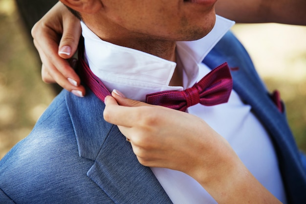 La novia pone la corbata al novio. Detalles de la boda. Enfoque selectivo.
