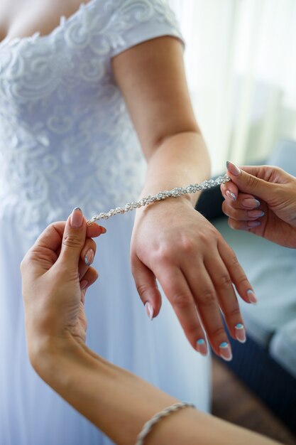 La novia se pone joyas de boda el día de la boda.