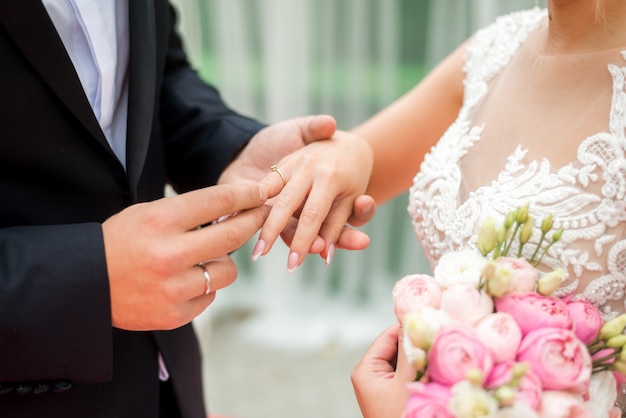 Novia poniendo el anillo de bodas en el dedo del novio.