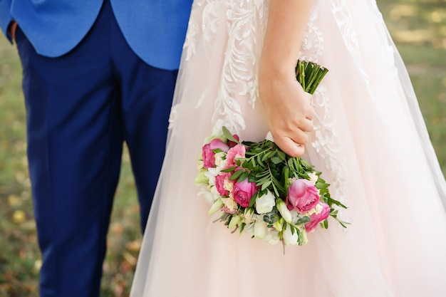 Novia que sostiene el ramo colorido de la boda de flores frescas