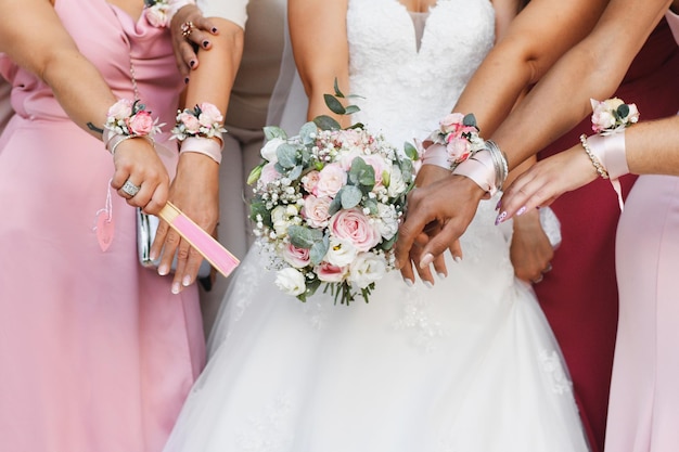 Una novia con un ramo y damas de honor con vestidos y pulseras idénticos.