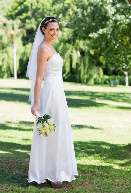 Novia con ramo de flores en el parque