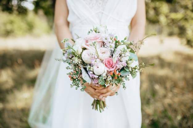 Novia con ramo de novia con flores blancas y rosadas