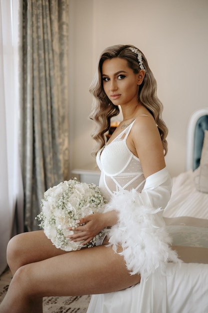 Novia sentada en una cama con un ramo de flores