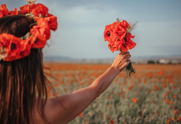 Novia sosteniendo un ramo de flores de amapola