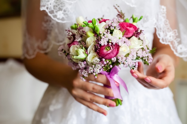 Novia sosteniendo un ramo de rosas.