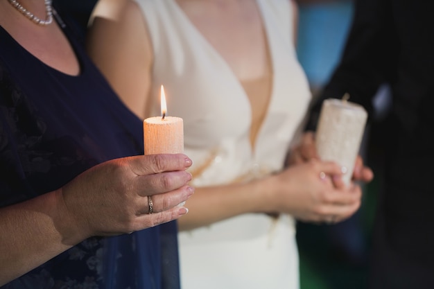 Novia sosteniendo una vela en sus manos