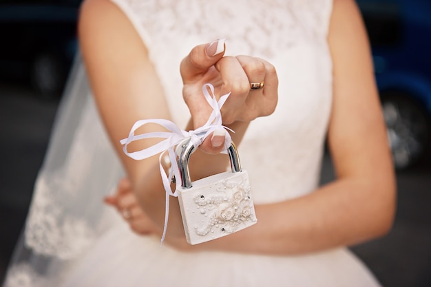 La novia sostiene un candado cerrado blanco