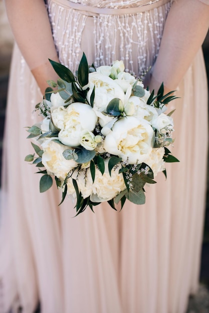 La novia sostiene un elegante ramo de peonías blancas Ramo para la novia