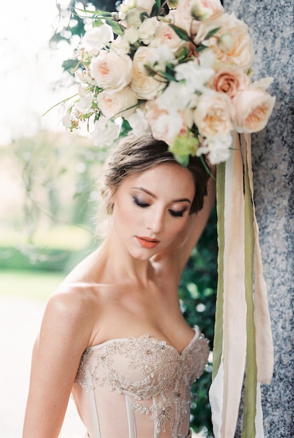 La novia sostiene un ramo de flores sobre su cabeza