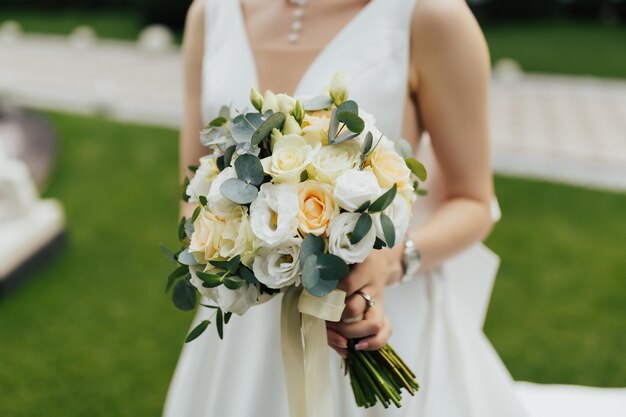 La novia sostiene un ramo de novia con flores blancas.