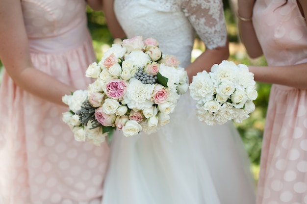 La novia y su dama de honor en rosa con flores en la boda.