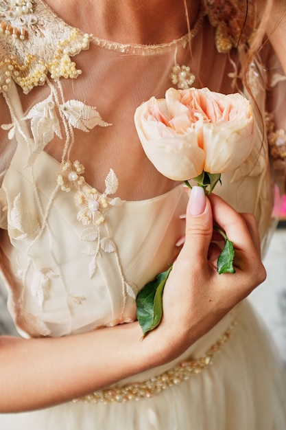 La novia tiene una flor rosa en las manos