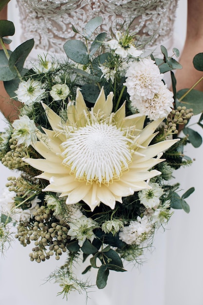 La novia tiene un hermoso ramo de flores de protea.