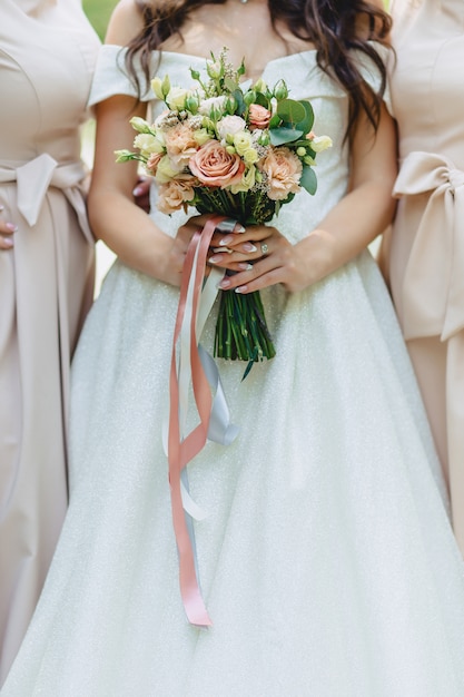 La novia tiene un ramo de boda en sus manos.