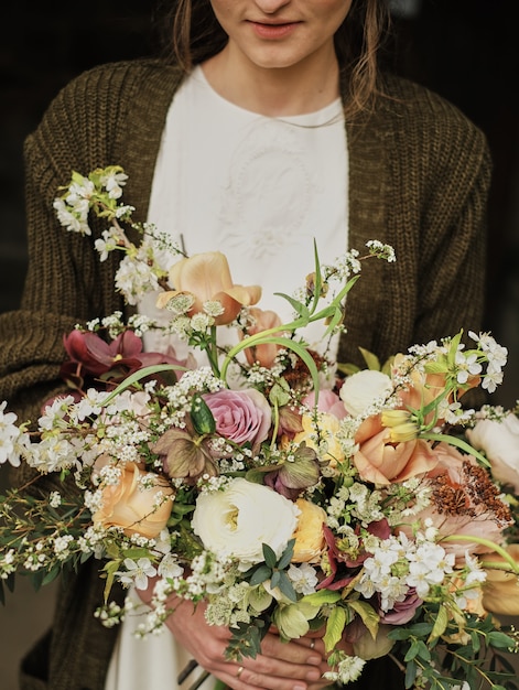 Foto la novia tiene un ramo en un día nublado. primer plano, gran ramo hermoso