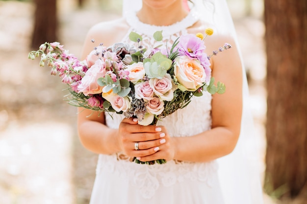 La novia tiene un ramo de novia. ramo delicado con rosas amarillas y eucalipto.