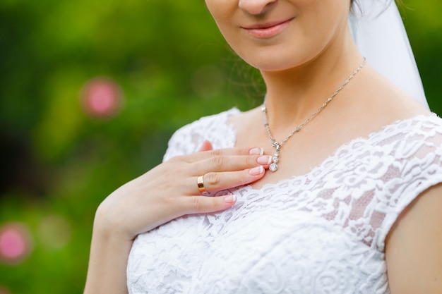 Novia tocando el colgante de diamantes brillantes