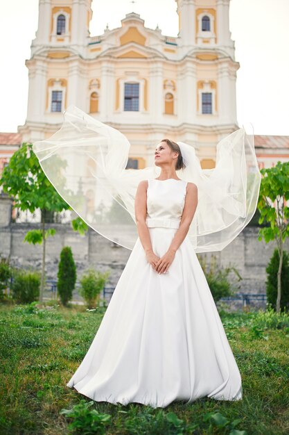 Novia con velo delante de la iglesia