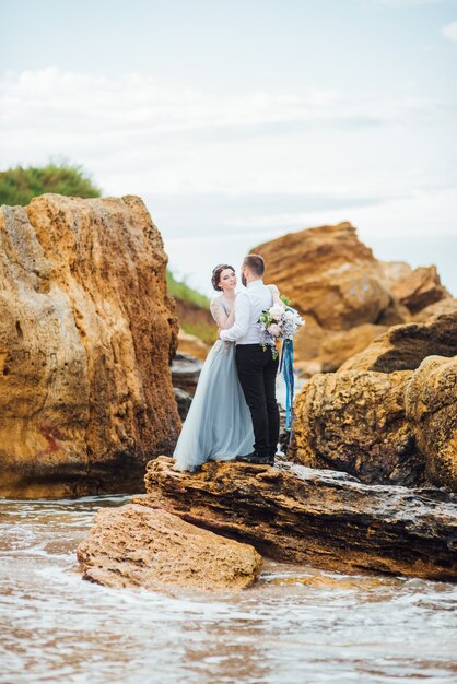 novia en un vestido azul caminar a lo largo de la orilla del mar