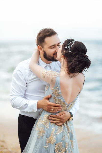 novia en un vestido azul caminar a lo largo de la orilla del mar