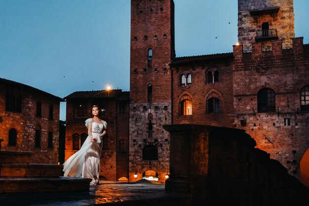 Una novia con un vestido blanco en el casco antiguo de San Gimignano.