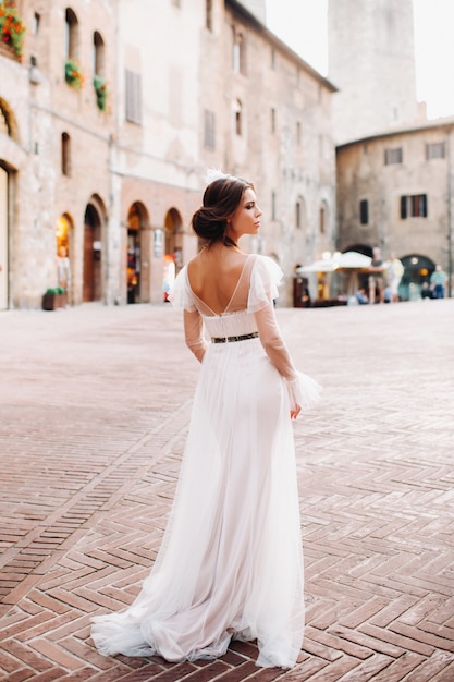 Una novia con un vestido blanco en el casco antiguo de San Gimignano