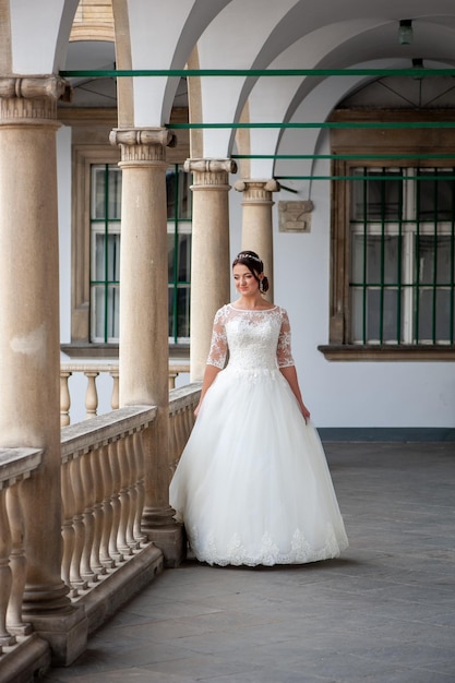 Una novia con un vestido blanco se encuentra en un balcón.