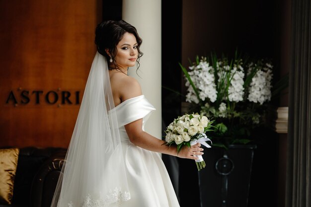 una novia en un vestido blanco está de pie frente a un letrero que dice cita la palabra cita