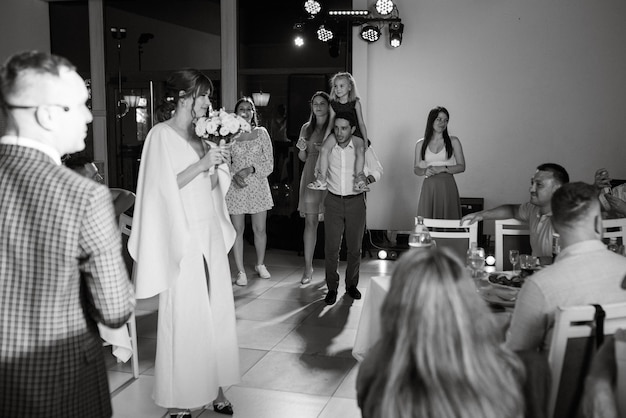 Una novia con un vestido blanco lanza un ramo de novia