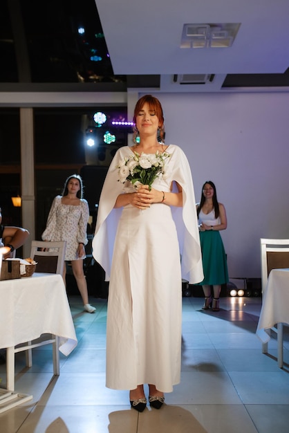 Una novia con un vestido blanco lanza un ramo de novia