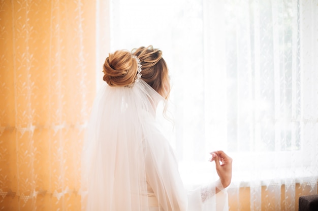 Novia con vestido blanco posando mientras se prepara para la ceremonia de la boda